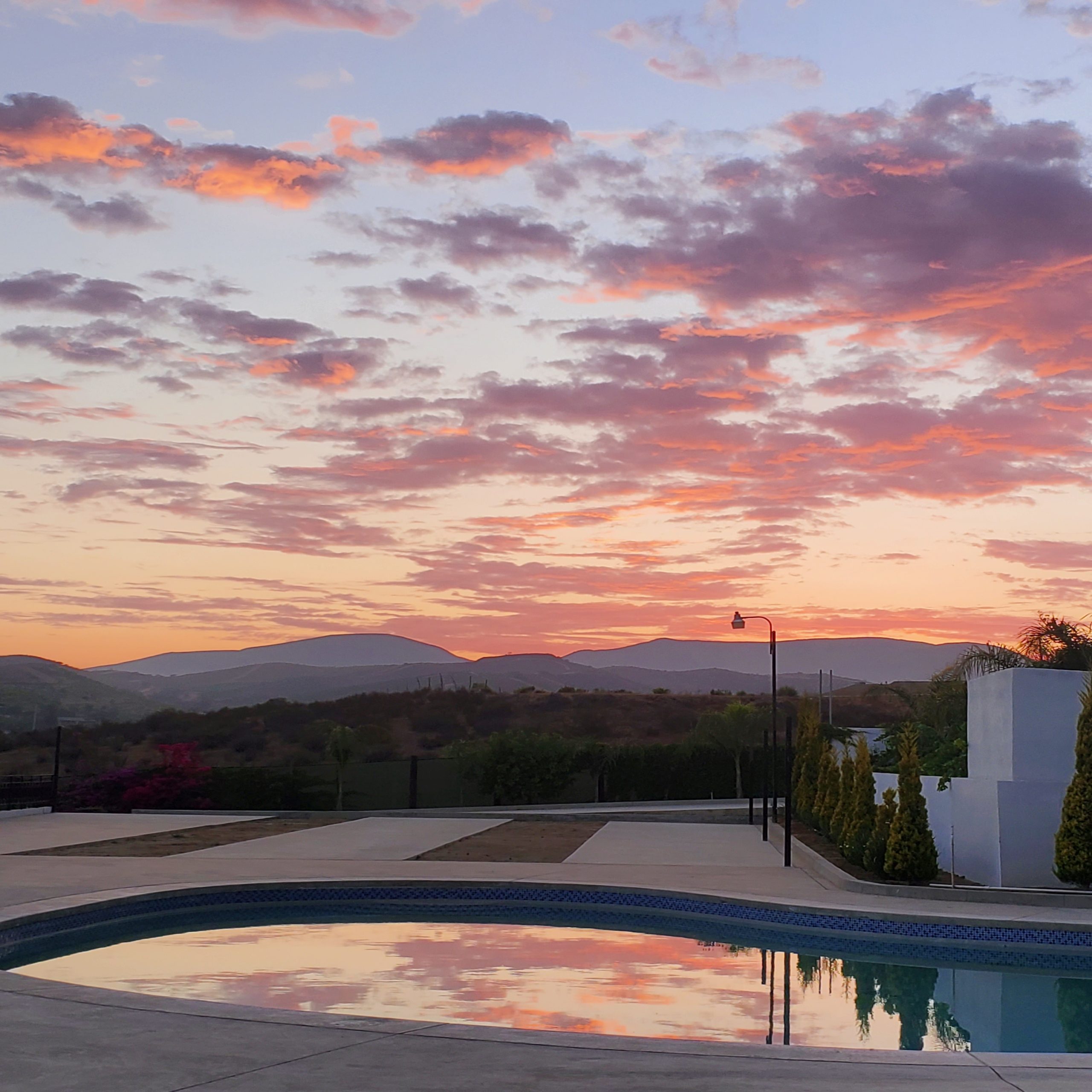Pink sunset over the pool and mountains at Iboga Treatment Center in Ensenada, Mexico