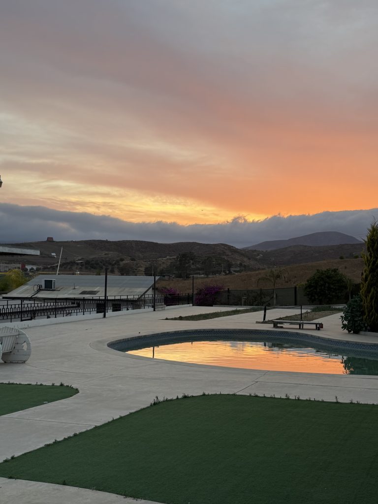 Saltwater pool at sunset with mountain views at Iboga Treatment Center in Ensenada, Mexico